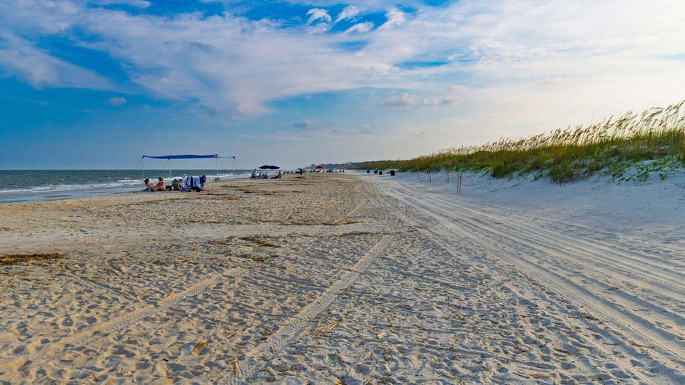 A wide sandy beach and grassy dunes set the scene for relaxed days by the water.