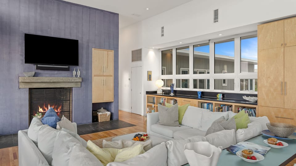 Ocean views fill this airy living space, where a fireplace, TV, and dining nook create an inviting place to gather.