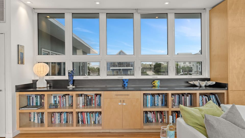 Built-in bookshelves and a wall of windows create a bright reading nook with plenty of character and natural light.