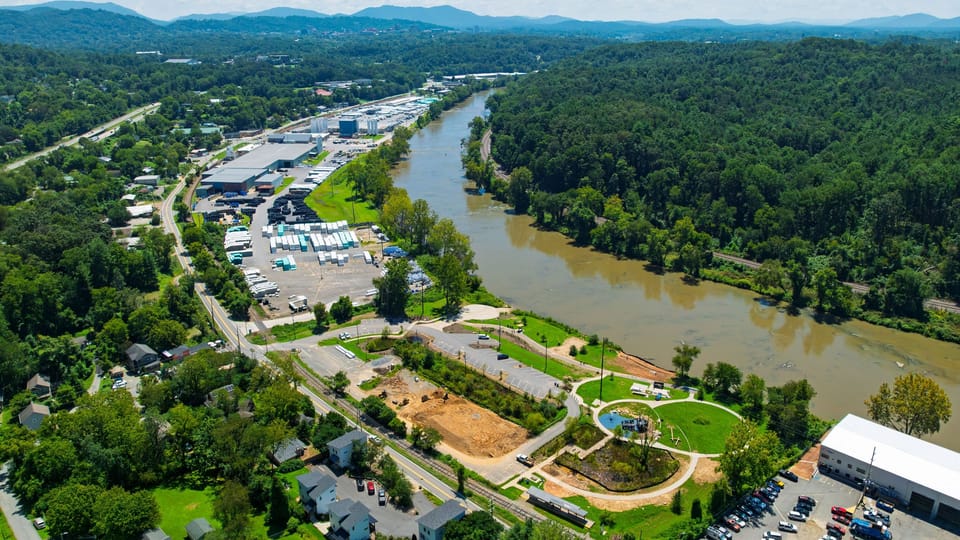 An aerial view highlights the home’s close proximity to the French Broad River, with sweeping river and mountain scenery stretching into the distance.