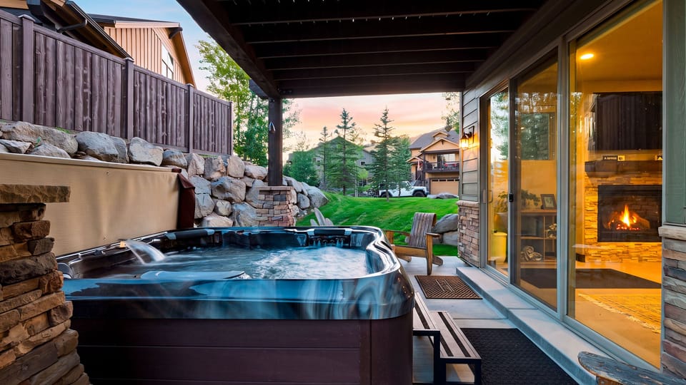 Soak in the covered hot tub while the indoor fireplace glows just beyond the glass.
