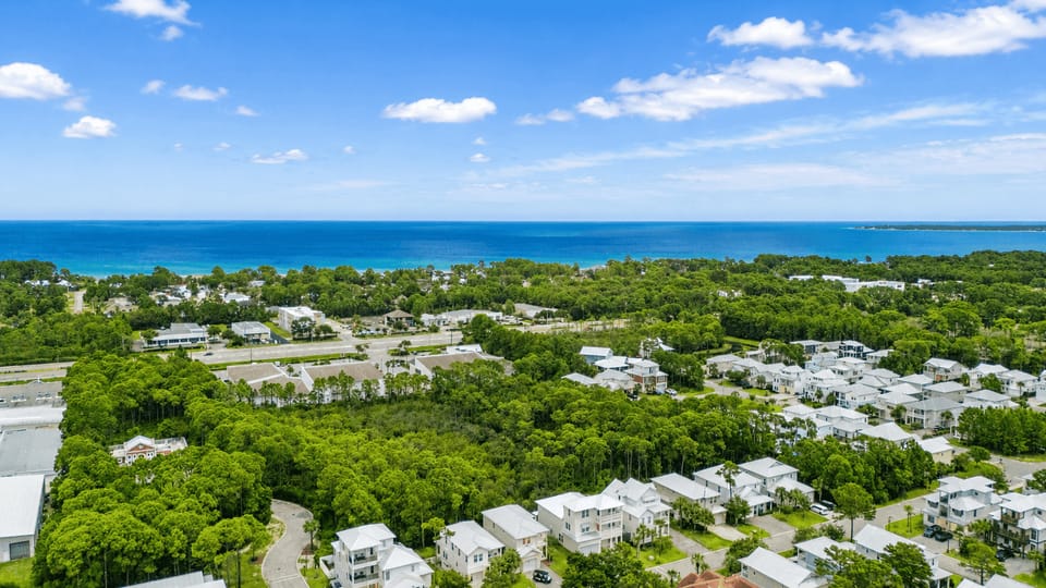 Aerial views showcase the home’s coastal setting and the shoreline just beyond the neighborhood.