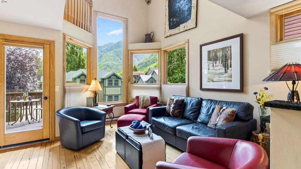 Relax in a bright vaulted living room where expansive windows showcase the surrounding mountains.