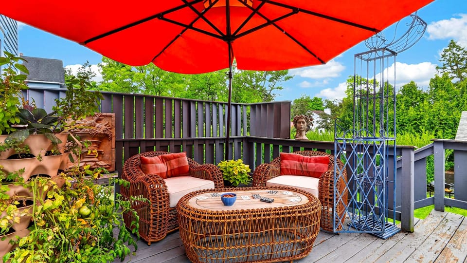 Spacious patio lounge with outdoor seating under a vibrant red umbrella—perfect for alfresco dining and entertaining.