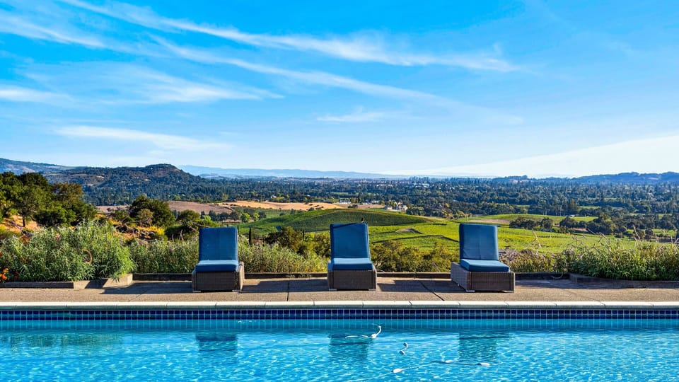 Pool deck loungers with panoramic hill and valley views.