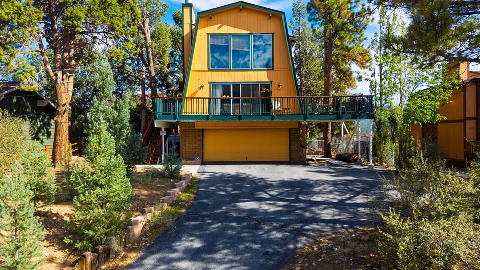 Gather in the warm, wood-paneled living room with vaulted ceilings, plush seating, and a striking stone fireplace.
