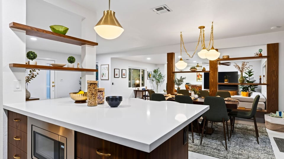 The open kitchen and waterfall island create a stylish hub for casual meals, conversation, and group time.