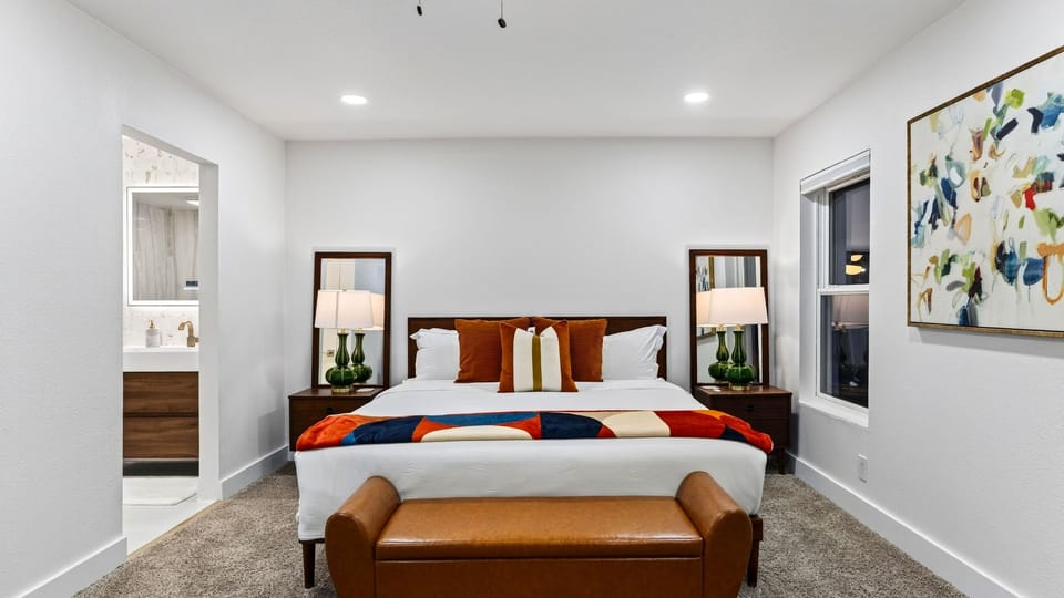 The primary bedroom features a king bed, TV, patio access, and private ensuite bathroom for a comfortable retreat.