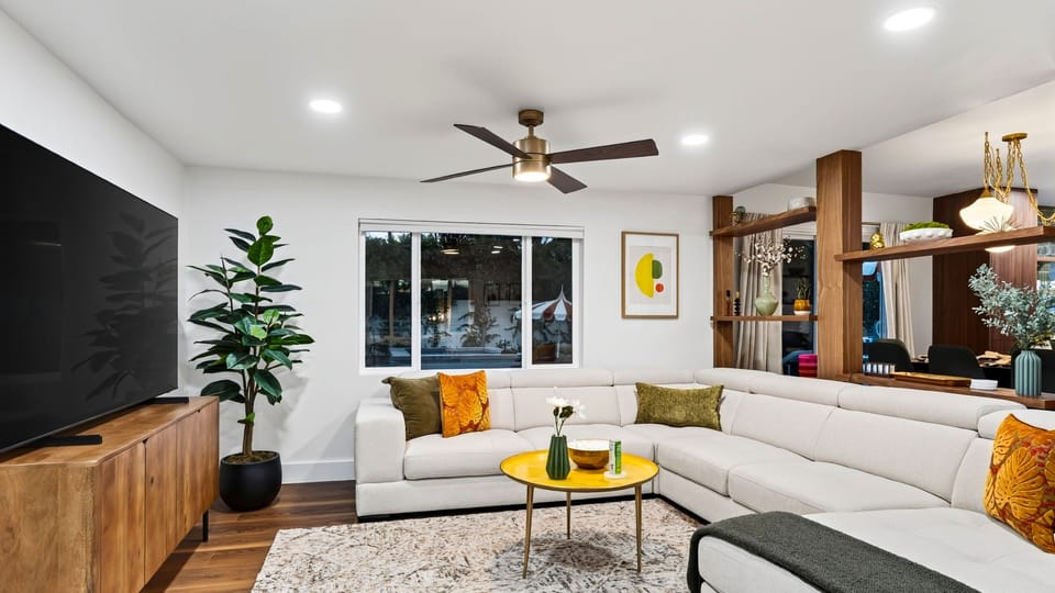A bright, spacious living room with generous sectional seating and a large TV for easy group downtime.