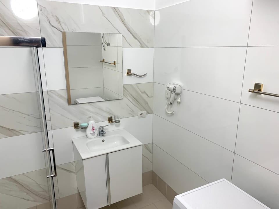 Shower, Toilet, Bathroom, hair dryier, towels, washing machine