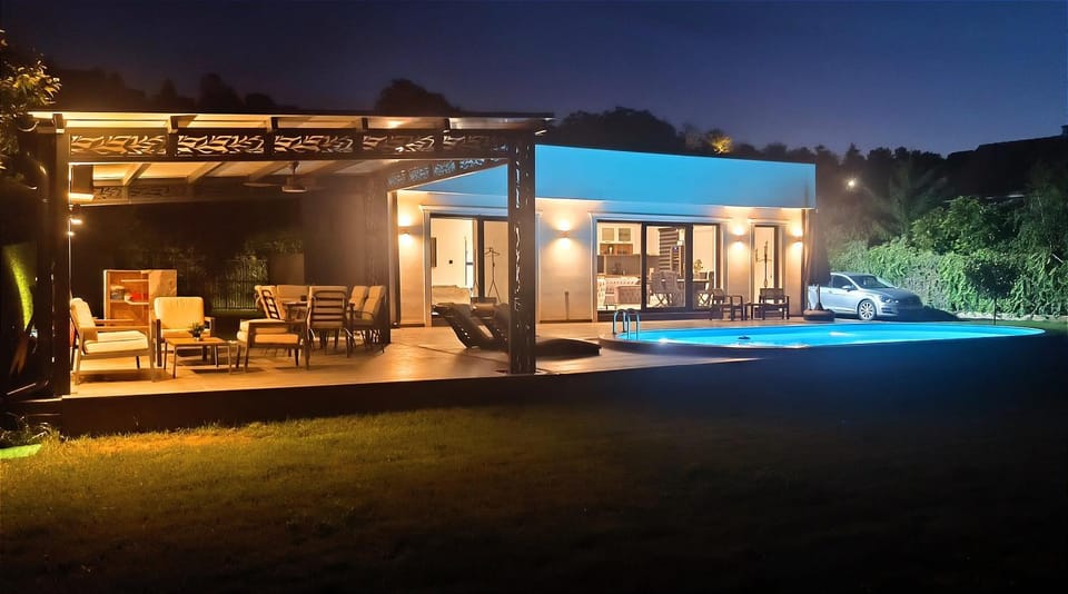 Property building, Patio, Night, Natural landscape, Garden, Living room, Seating area, Garden view, Pool view, Swimming pool, sunbed