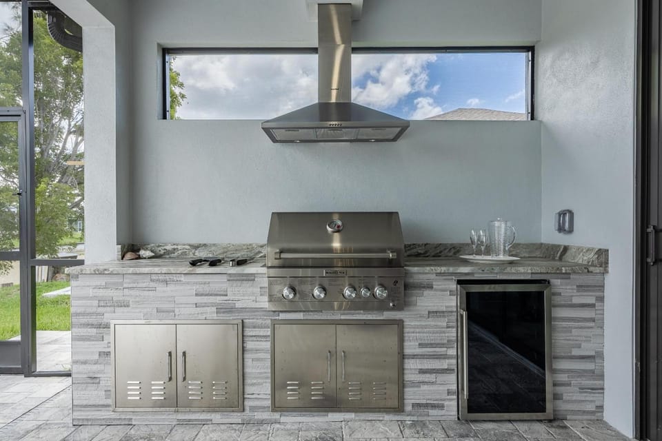 Pool overlooking canal, Outdoor Grilling station - Villa Sand Dollar Siesta House in Cape Coral