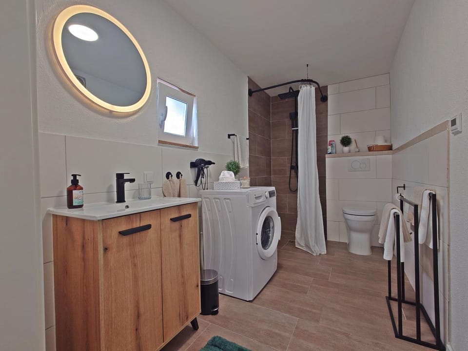 Shower, Toilet, Bathroom, hair dryier, towels, washing machine