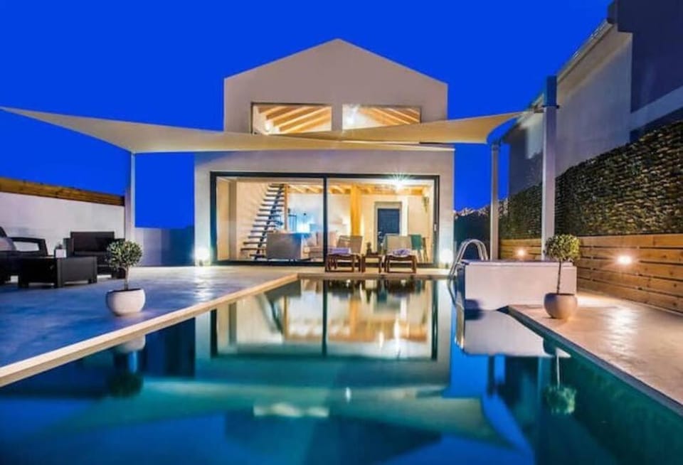 Property building, Patio, Night, View (from property/room), Balcony/Terrace, Living room, Seating area, Pool view, Swimming pool