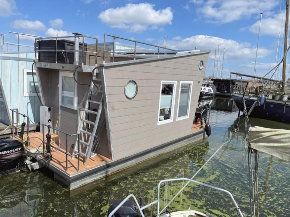 Tiny lake houses near the beach and centre by Weltevreden Experience Docked boat in Zeewolde