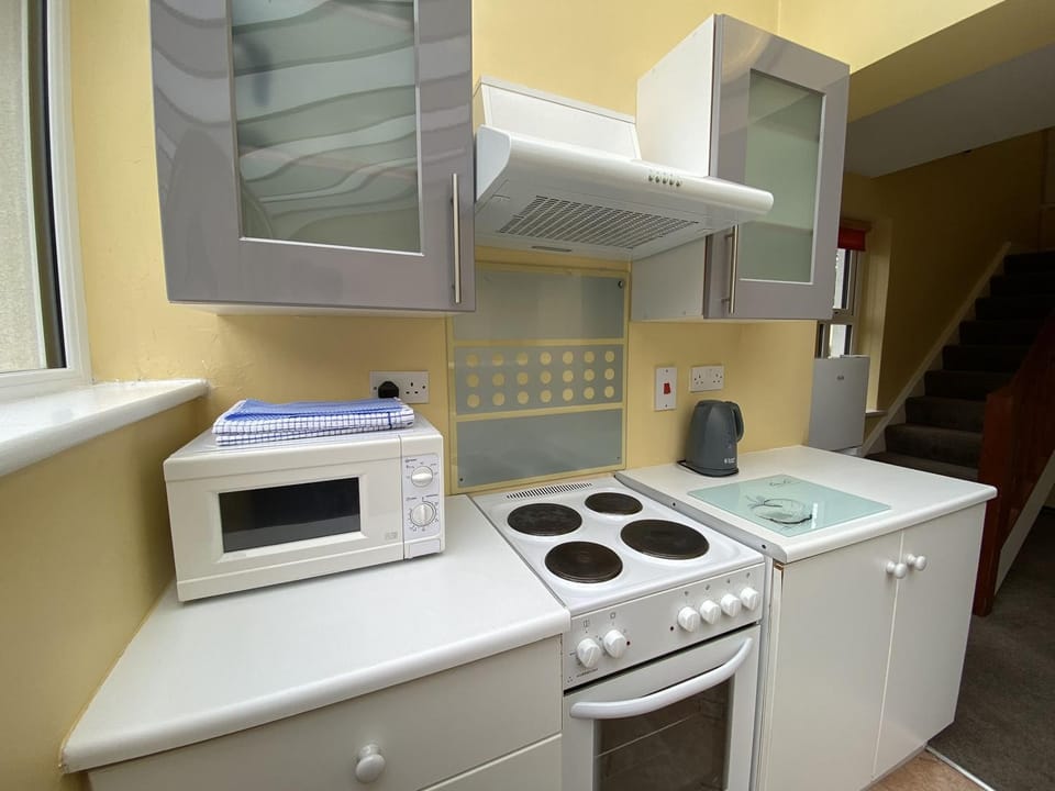 Kitchen or kitchenette, dishwasher, microwave, oven, stove, toaster, washing machine