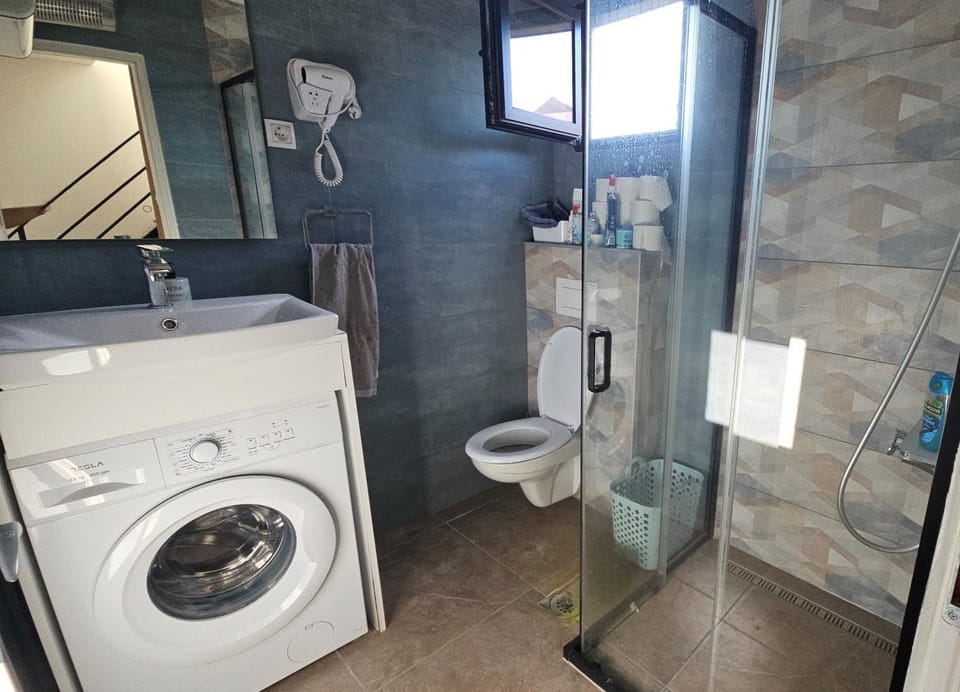 Shower, Toilet, Bathroom, hair dryier, towels, washing machine