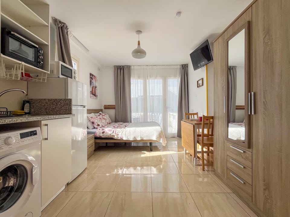 Bed, TV and multimedia, Kitchen or kitchenette, Photo of the whole room, Seating area, oven, stove, washing machine