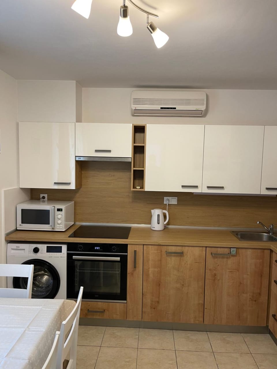 Kitchen or kitchenette, microwave, oven, stove, washing machine, air conditioner