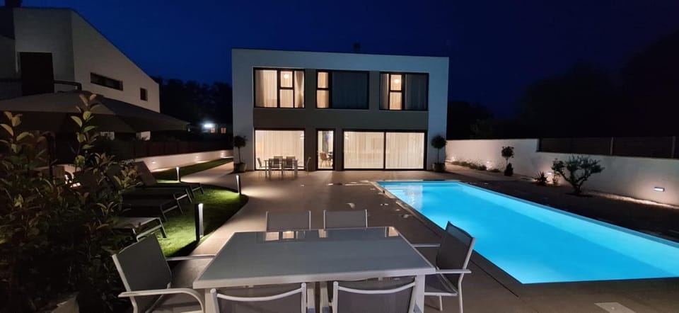 Property building, Patio, Night, Living room, Seating area, Dining area, Pool view, Swimming pool, sunbed