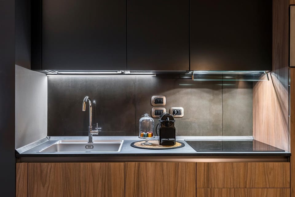 Eco Chic room with sofa bed and kitchen by Design Club Collection Apartment in Bologna
