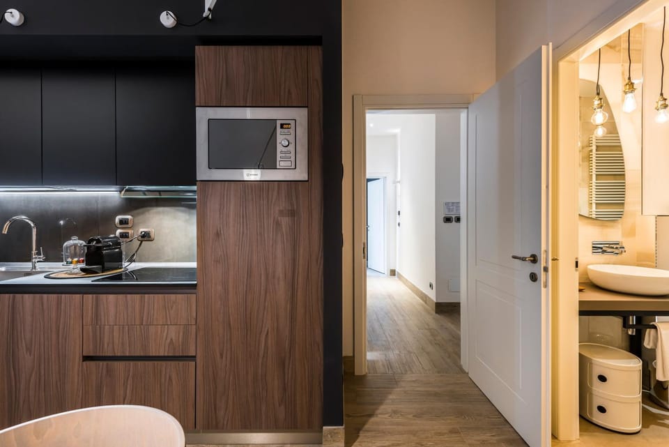 Eco Chic room with sofa bed and kitchen by Design Club Collection Apartment in Bologna