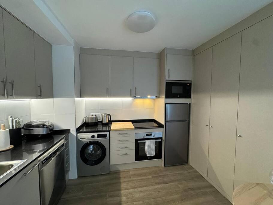 Kitchen or kitchenette, dishwasher, oven, stove, toaster, washing machine
