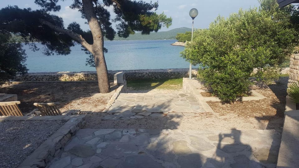 Stone house with a boat Country House in Tisno