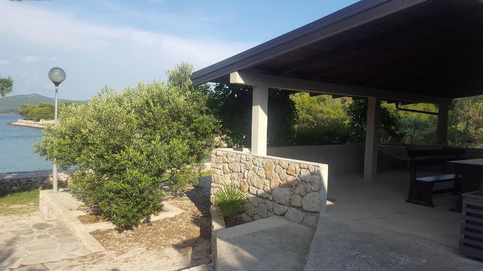 Stone house with a boat Country House in Tisno