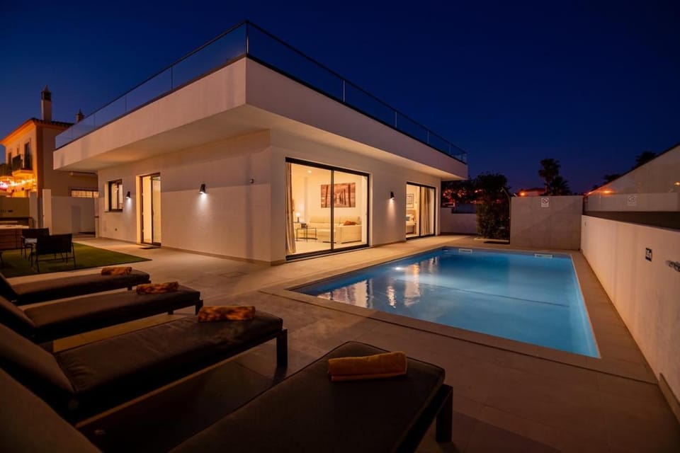 Property building, Patio, Night, Living room, Seating area, Pool view, Swimming pool, sunbed