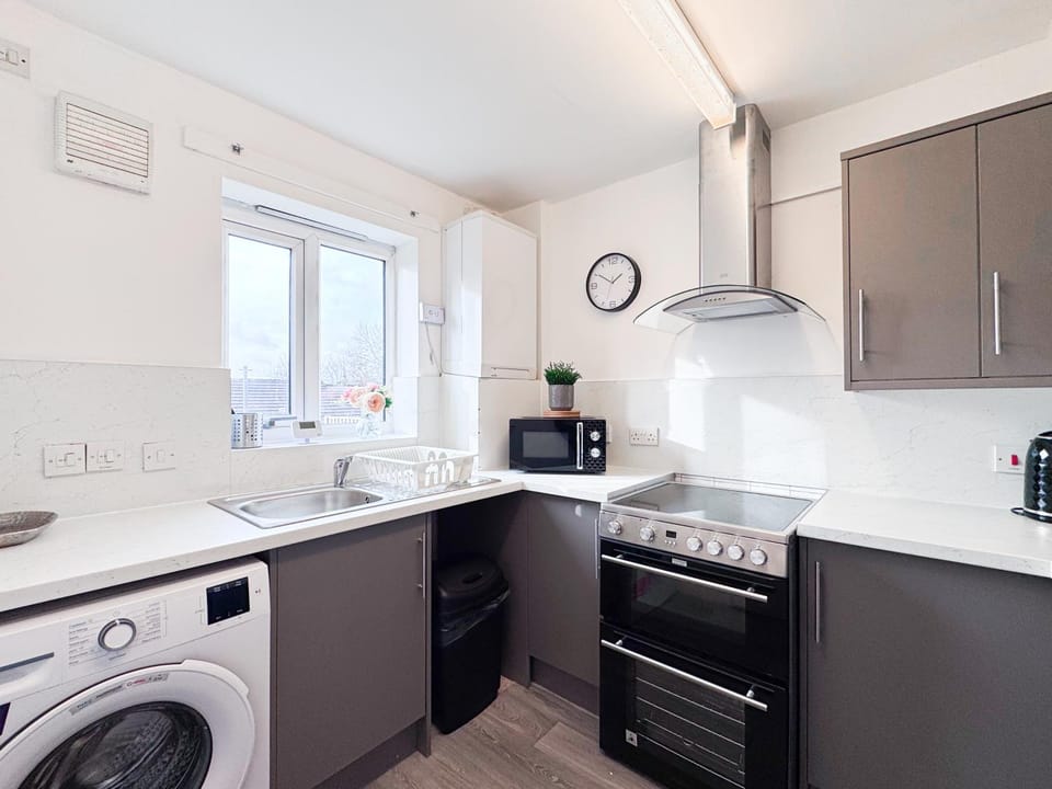 Kitchen or kitchenette, heating, microwave, oven, stove, toaster, washing machine