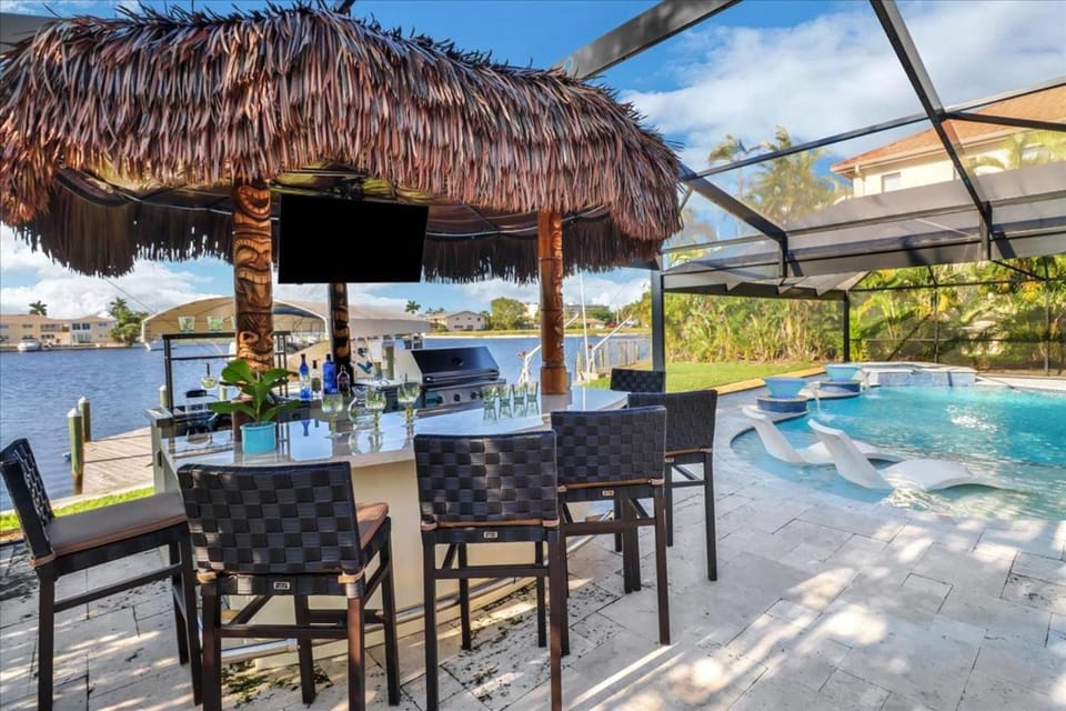 Neptunes Villa-Canalfront, Heated Pool, Outdoor Kitchen, Tiki Hut House in Cape Coral