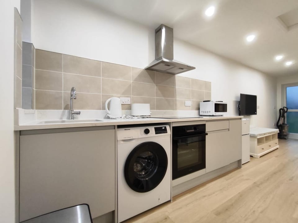 Kitchen or kitchenette, microwave, oven, stove, toaster, washing machine