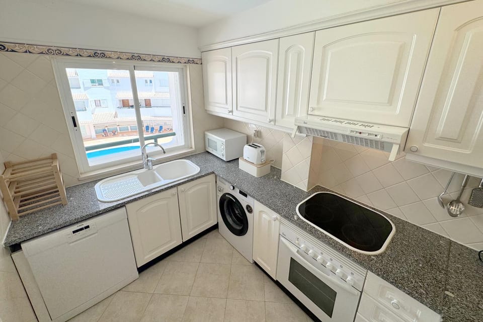 Kitchen or kitchenette, dishwasher, microwave, oven, stove, toaster, washing machine