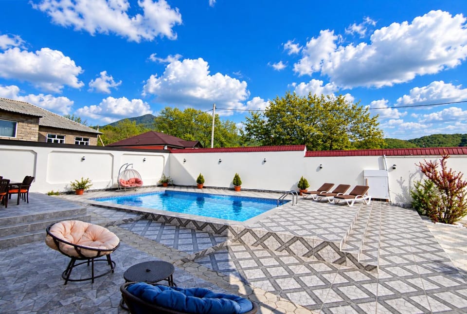 Property building, Patio, Day, Natural landscape, Pool view, Swimming pool, sunbed