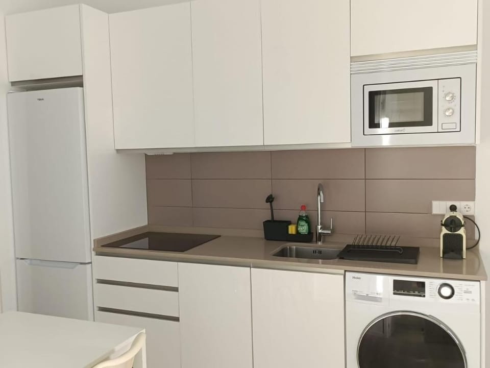 Kitchen or kitchenette, microwave, stove, washing machine, dryer