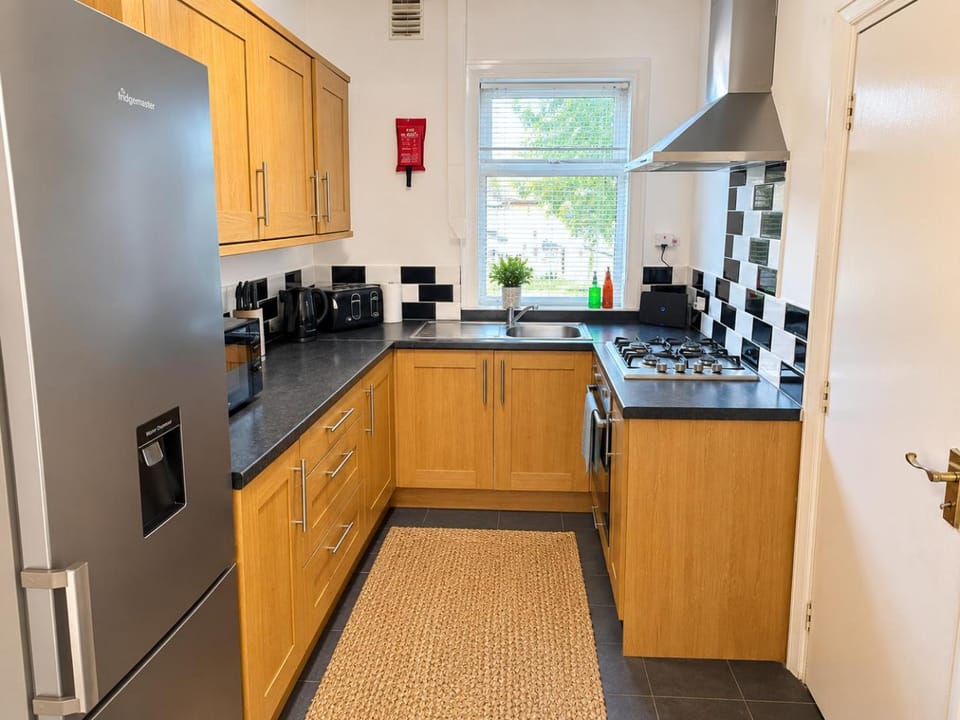 Kitchen or kitchenette, heating, microwave, oven, storage, stove, toaster, towels, kitchen