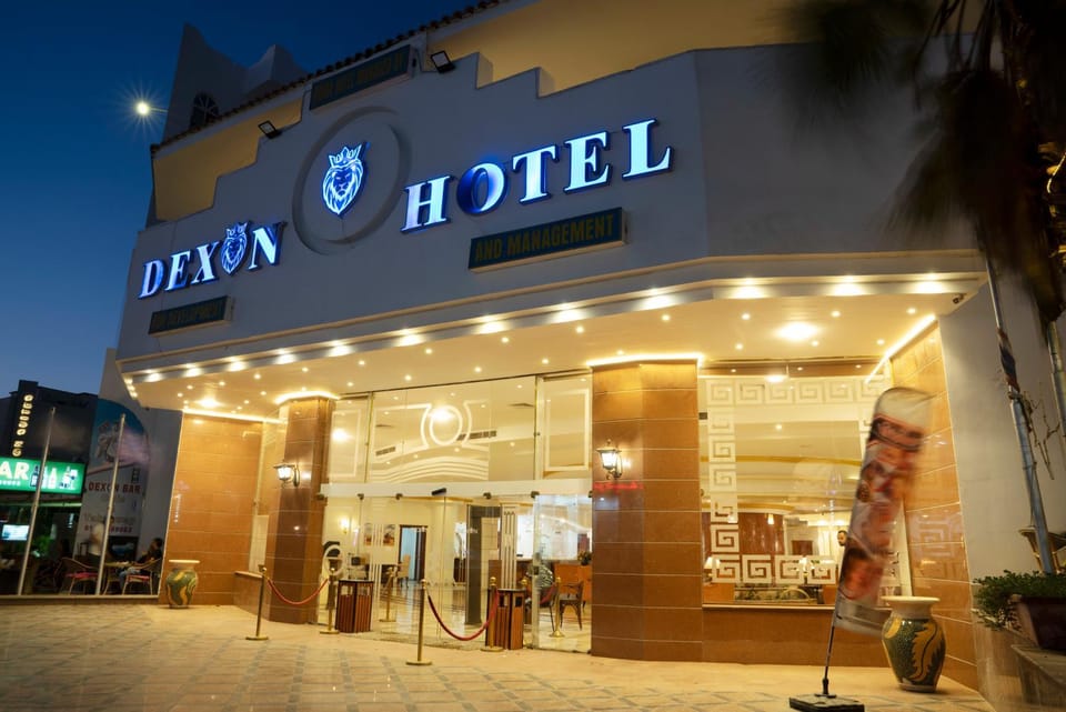 Property building, Facade/entrance, Night, People, Property logo or sign, Logo/Certificate/Sign, Text overlay, City view, Street view, group of guests
