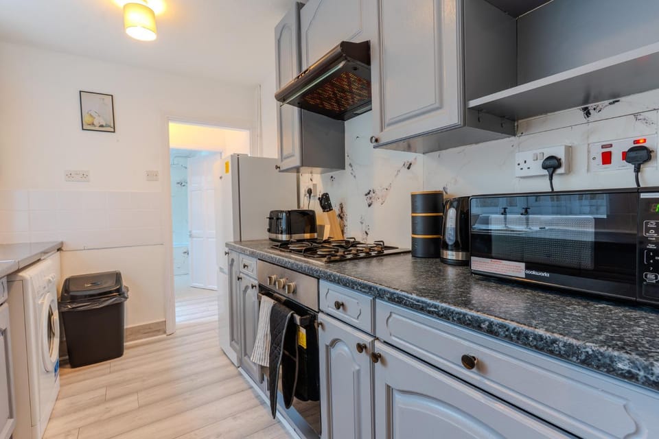 Kitchen or kitchenette, microwave, oven, stove, toaster, washing machine