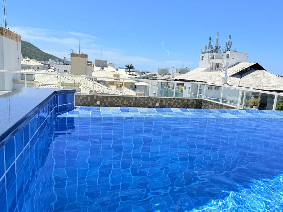 Residencial com piscina de borda infinita a poucos passos da praia e próxima à sorveteria House in Florianopolis
