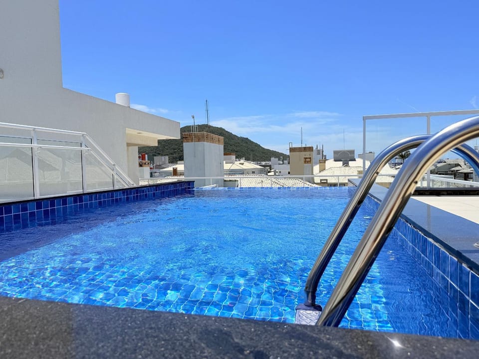 Residencial com piscina de borda infinita a poucos passos da praia e próxima à sorveteria House in Florianopolis