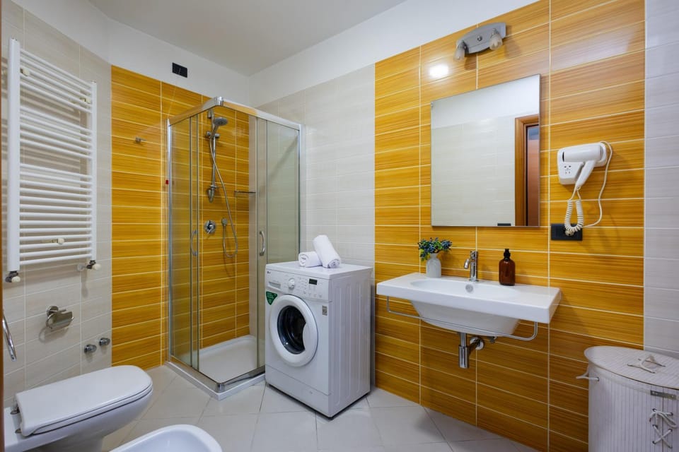 Shower, Toilet, Bathroom, bidet, hair dryier, towels, washing machine, dryer