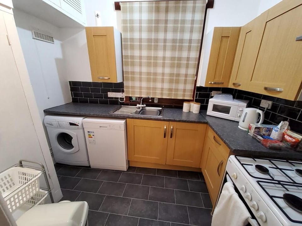 Kitchen or kitchenette, dishwasher, microwave, oven, stove, toaster, washing machine