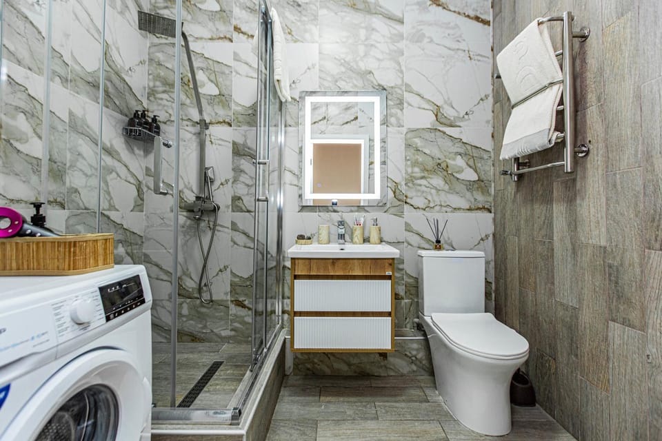 Shower, Toilet, Bathroom, hair dryier, towels, washing machine, dryer