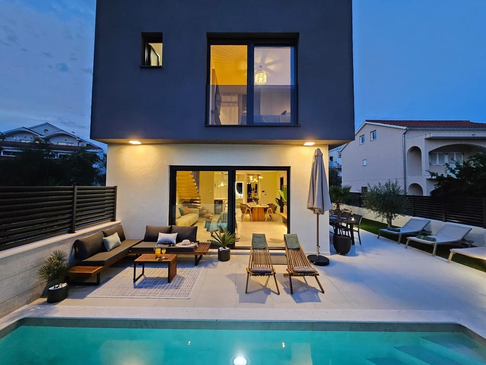 Property building, Patio, Night, Seating area, Pool view, Swimming pool, sunbed