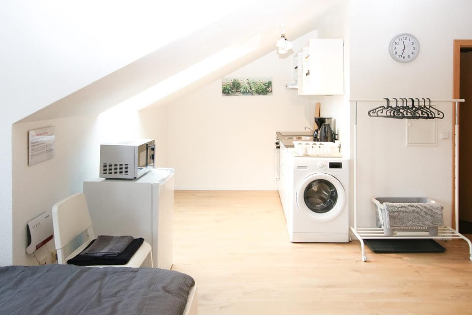 Photo of the whole room, microwave, washing machine, kitchen