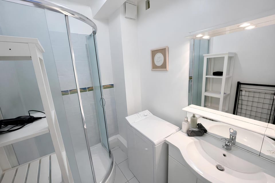 Shower, Toilet, Bathroom, hair dryier, towels, washing machine, washing machine