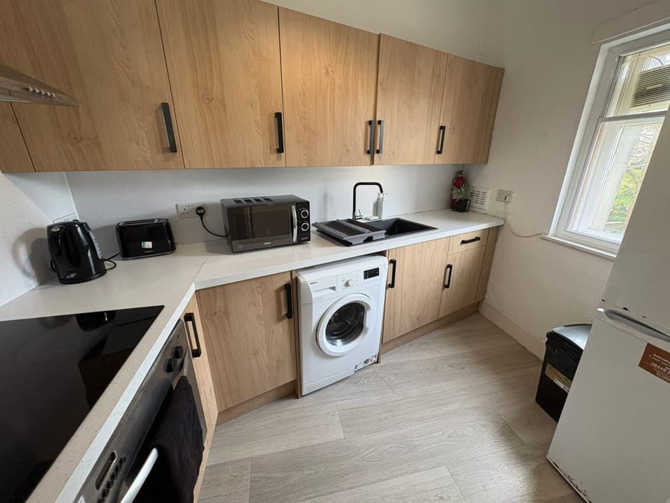 Kitchen or kitchenette, microwave, oven, stove, toaster, washing machine