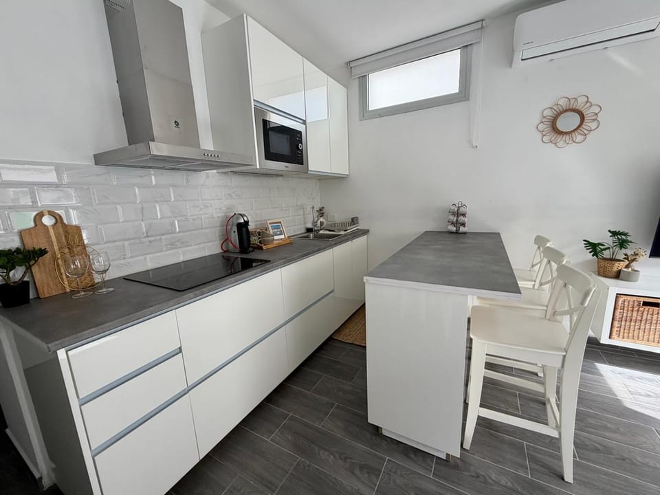 Kitchen or kitchenette, microwave, storage, stove, toaster, air conditioner