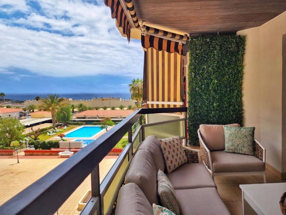 View (from property/room), Balcony/Terrace, Living room, Seating area, Pool view, Swimming pool